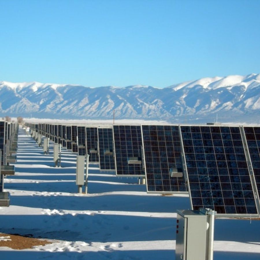 many solar panels set up at the foot of a mountain