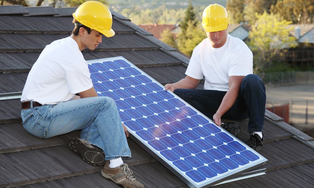 workers setting up solar panels on a roof
