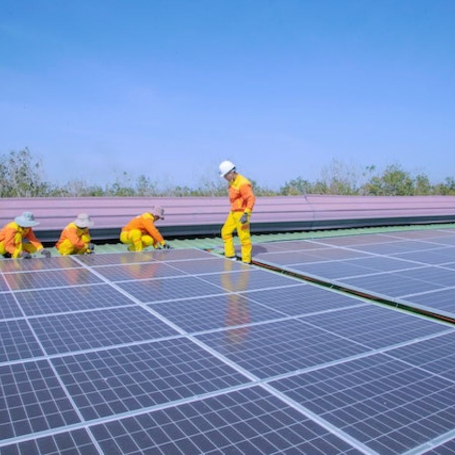 workers installing solar panels on a field